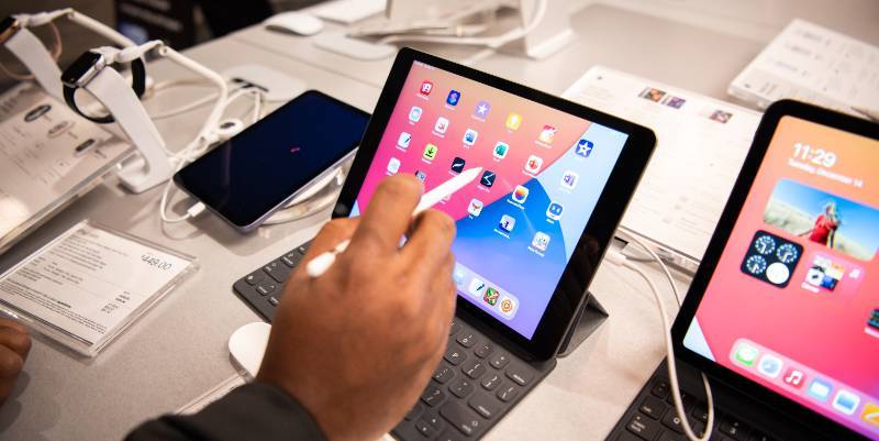 hand holding an apple pencil and interacting with a display model iPad